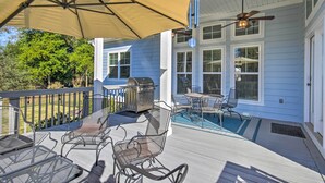 A covered outdoor patio with metal chairs, a grill, and a ceiling fan. - North Augusta Getaway w/ Large Deck & Yard (North Augusta)