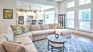 A spacious living room with a sectional sofa, a round coffee table, and a view of the kitchen and dining area. - North Augusta Getaway w/ Large Deck & Yard (North Augusta)