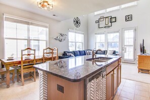 A spacious kitchen with a large island, wooden chairs, and a dining table. - 4 Mi Shuttle Ride to Ocean: Bethany Beach Getaway (Millville)