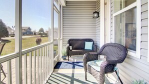A covered porch with a wicker sofa and chair, a potted plant, and a view of the yard. - 4 Mi Shuttle Ride to Ocean: Bethany Beach Getaway (Millville)