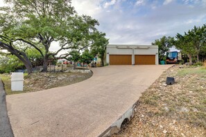 A driveway leading to a garage with a truck parked nearby. - Luxe Lake Travis Vacation Rental w/ Heated Pool (Leander)