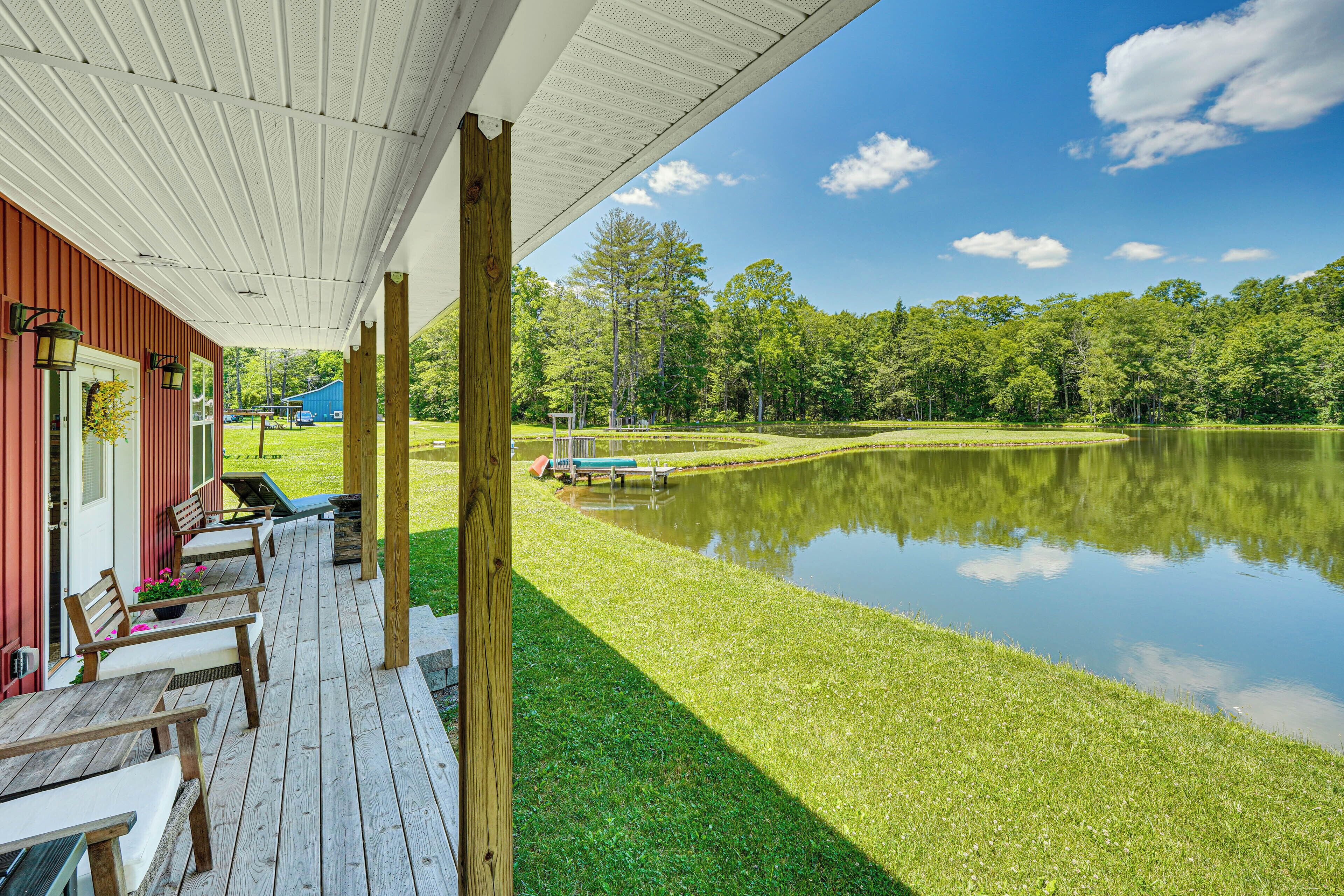 A wooden deck with outdoor seating and a view of a lake.