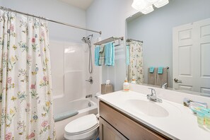 A bathroom with a shower, toilet, sink, and a mirror. - Close to Slopes: Lakeside Cottage in Pocono Mtns (Brodheadsville)