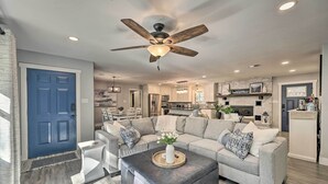A modern living room with a sectional sofa, a coffee table, and a ceiling fan.