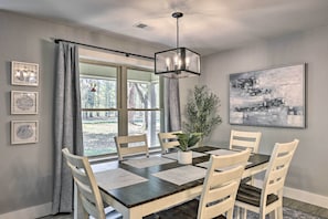 A dining room with a dark wooden table, white chairs, and a hanging light fixture. - Updated Royal Retreat on 5 Acres: 'hidden Creek' (Royal)