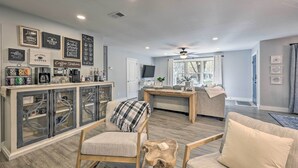 A modern living room with a bar area, a sofa, and a coffee station.