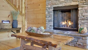 Un intérieur en bois avec une cheminée en pierre, un banc en bois et un panier posé sur la cheminée.