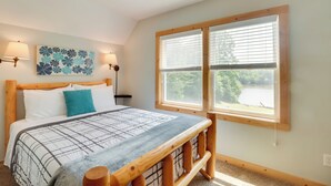 A bedroom with a wooden bed, a view of a lake, and a ceiling fan. - Waterfront, Deck: Peaceful Louisa Cottage Escape (Louisa)