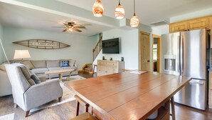 A spacious kitchen with a large wooden table, a built-in refrigerator, and pendant lighting. - Waterfront, Deck: Peaceful Louisa Cottage Escape (Louisa)
