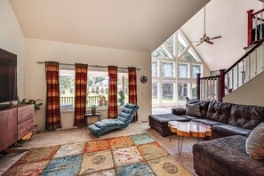 A living room with a sofa, a recliner, a coffee table, and a large window with curtains. - Hot Tub, Deck + Game Room: Port Angeles Home (Port Angeles)
