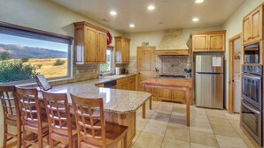 A kitchen with wooden cabinets, granite countertops, stainless steel appliances, and a view of the mountains. - Eden Townhome w/ Mtn View + Shuttle to Powder Mtn! (Eden)