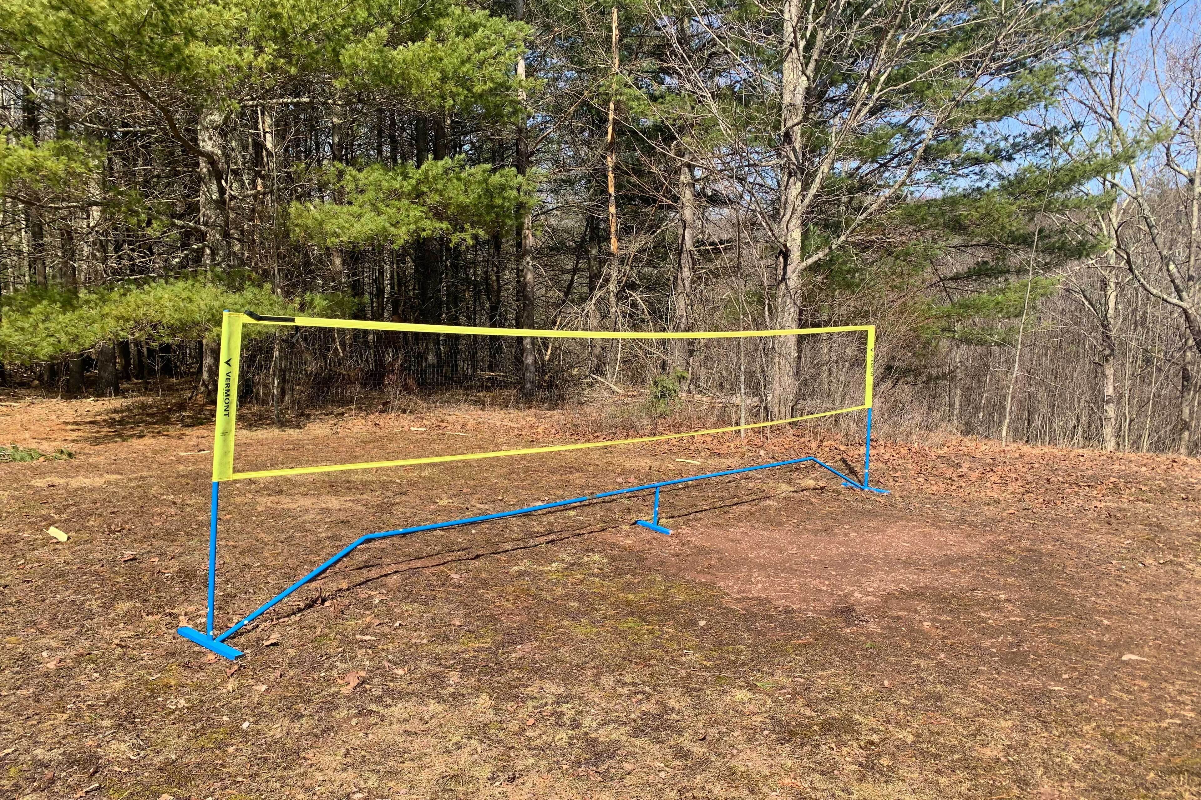 Une structure métallique jaune et bleue située dans une zone boisée.