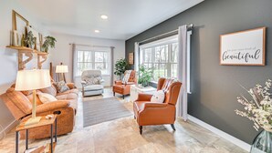 A spacious living room with a large window, a fireplace, and a cozy seating area.