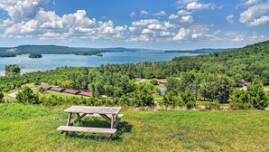 Une table de pique-nique installée dans un espace verdoyant, avec vue sur un terrain de golf et un lac.