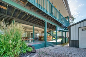 A covered outdoor patio with seating, a staircase, and a garage. - 2-level Home w/ Deck: 1/2 Mi to Lake Mcconaughy! (Lemoyne)