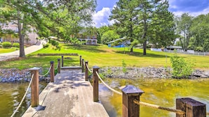 A wooden bridge over a pond with a grassy area and trees in the background. - Waterfront Piney Flats Home w/ Private Dock! (Piney Flats)