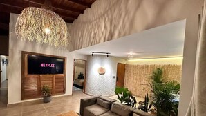 A modern living room with a sectional sofa, a wooden coffee table, and a TV displaying 'NETFLIX'. - Increible Casa con Jacuzzi en Poblado-lleras (Medellín)