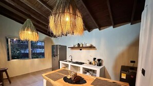 A modern kitchen with a central island, a refrigerator, and a hanging light fixture. - Increible Casa con Jacuzzi en Poblado-lleras (Medellín)