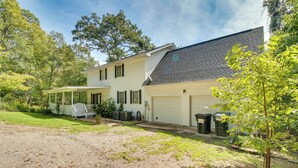 Een tweelaags huis met een overdekte veranda, een garage en een grindpad.