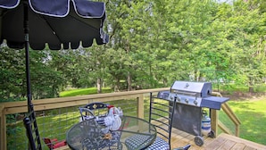 A deck with a grill, a table with chairs, and an umbrella. - Charming Country Cottage: 5 Mi to Downtown Tulsa! (Tulsa)