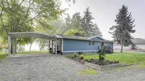 A house with a covered porch, a small garden, and a satellite dish. - Lakefront Mount Vernon Home w/ Private Dock! (Sedro-Woolley)