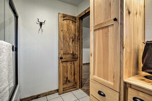 A wooden door with a rustic design, a small wall-mounted decoration, and a tiled floor. - Luxury Cabin w/ Pond, Working Ranch Near Nevada (Moundville)