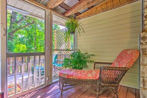 A covered porch with wicker furniture, a sliding door, and a hanging plant. - 'the Country Cottage in Union Mills w/ Porch! (Union Mills)
