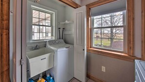 A laundry room with a washing machine, a sink, and a window with a view of the outside. - Peaceful Bird in Hand Home w/ Farmland Views! (Bird In Hand)