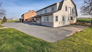 A large, two-story building with a prominent entrance and a covered porch area. - Peaceful Bird in Hand Home w/ Farmland Views! (Bird In Hand)