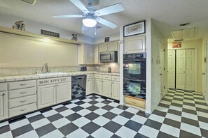 A kitchen with checkered flooring, a ceiling fan, and cabinets labeled "BAKERY" and "BON APPETIT". - 2 Mi to Lake Arlington: Spacious Escape w/ Deck (Arlington)