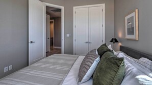 A bedroom with a bed, a door, and a wall-mounted lamp. - Spacious La Verkin Home: Near Zion Nat'l Park (La Verkin)