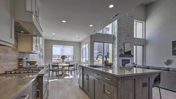 A modern kitchen with a large island, built-in appliances, and a stone accent wall. - Spacious La Verkin Home: Near Zion Nat'l Park (La Verkin)