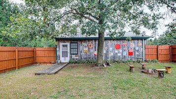 A wooden shed with various signs and a small ramp leading to the door.
