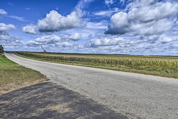 Une route de campagne, avec un ciel dégagé et quelques nuages.