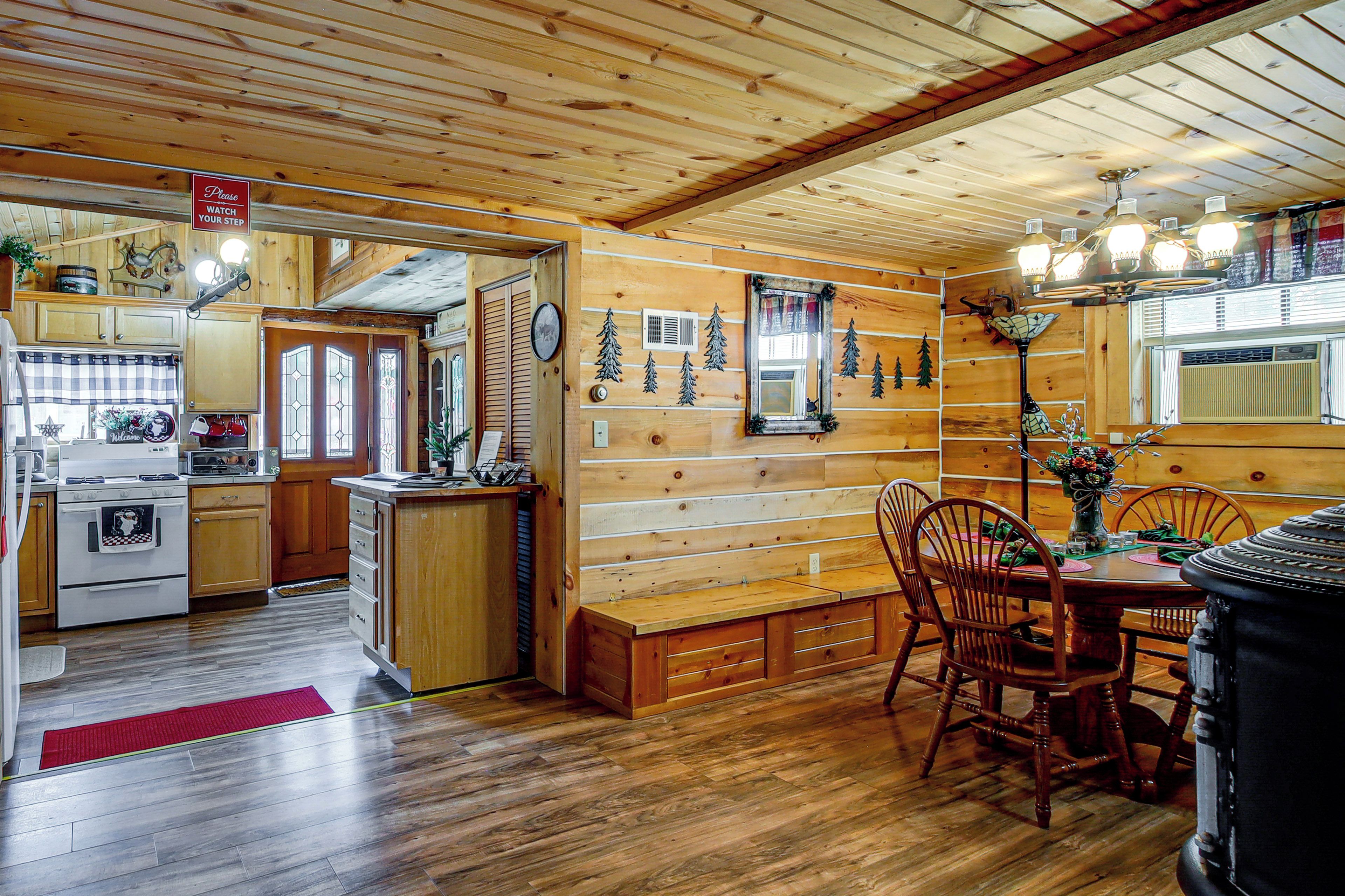 A wooden interior with a kitchen, dining area, and a mirror.
