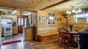 A wooden interior with a kitchen, dining area, and a mirror.