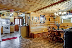 A wooden interior with a kitchen, dining area, and a mirror.