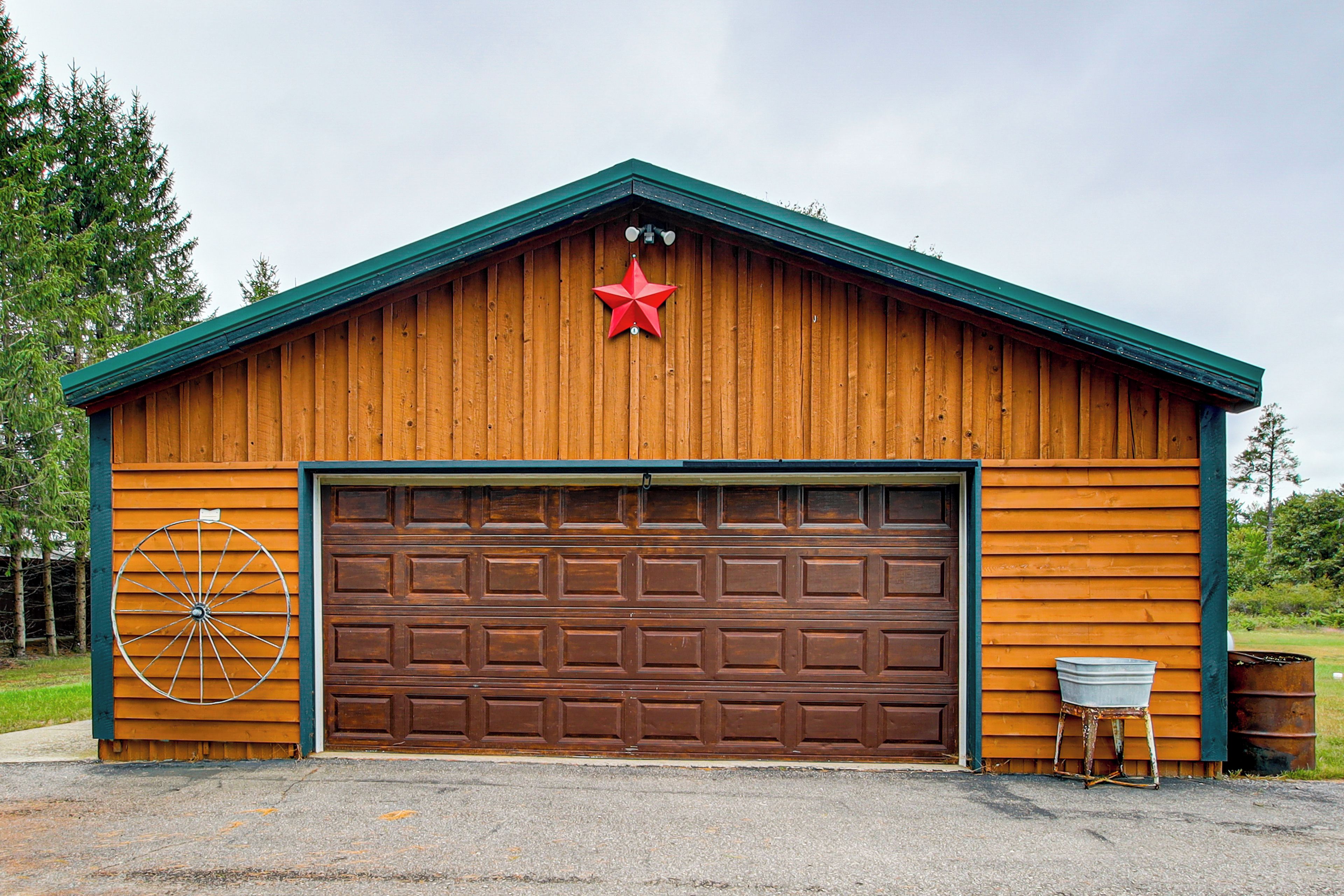 A wooden garage with a brown door, a red star decoration, and a wheel on the wall.