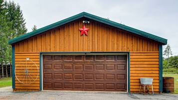 A wooden garage with a brown door, a red star decoration, and a wheel on the wall.