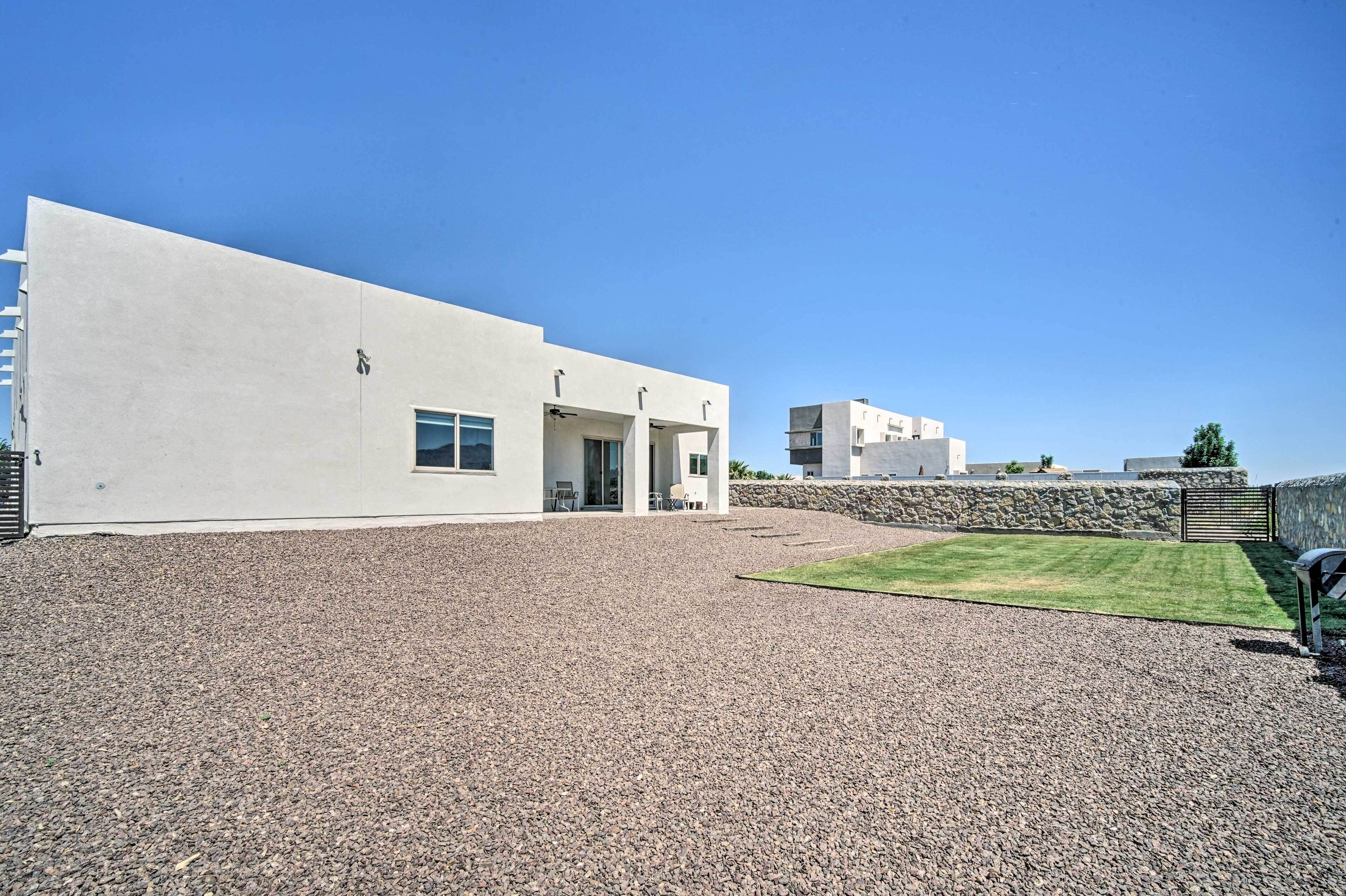 Un bâtiment moderne avec une allée en gravier et une petite pelouse.