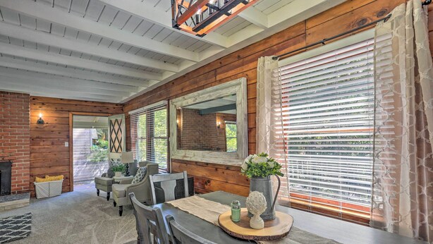 A cozy dining area with a wooden table, chairs, and a fireplace. - Half-mi to Shaver Lake: Cabin w/ Wraparound Deck (Shaver Lake)