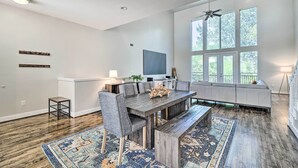 A spacious living room with a large wooden dining table, grey upholstered chairs, and a patterned rug. - 3-story Houston Townhome: 1 Mi to Minute Maid Park (Houston)