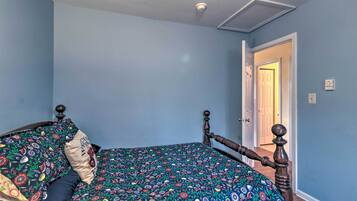 Un dormitorio con cama, una puerta y un interruptor de luz en la pared.