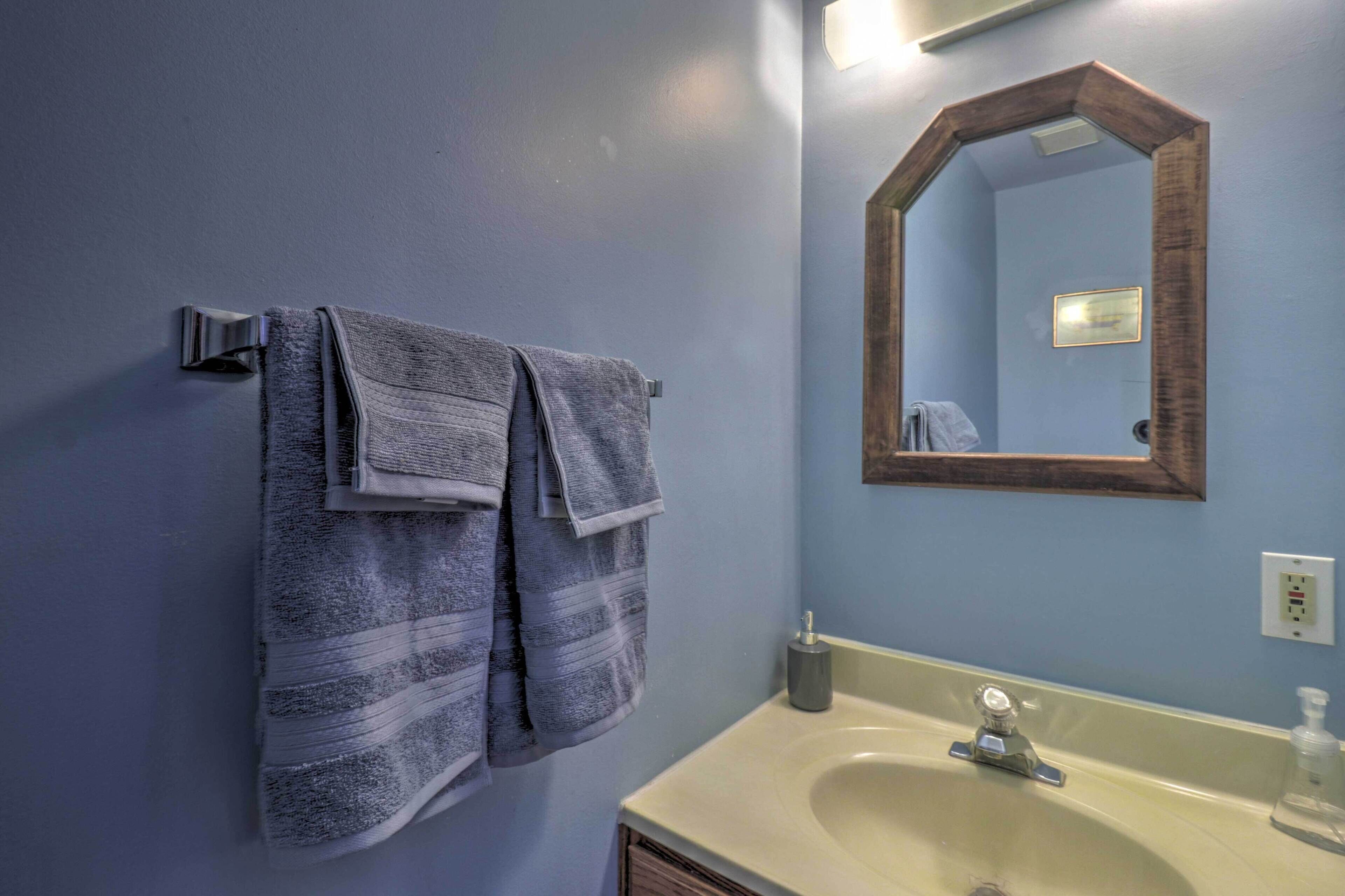 A bathroom with a sink, mirror, and towel rack.