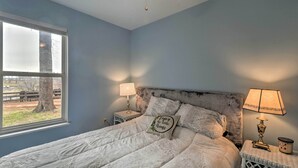 A bedroom with a bed, two bedside tables, a window, and a ceiling fan. - Cozy Rixeyville Cottage w/ Deck, Grill, & Stabling (Rixeyville)