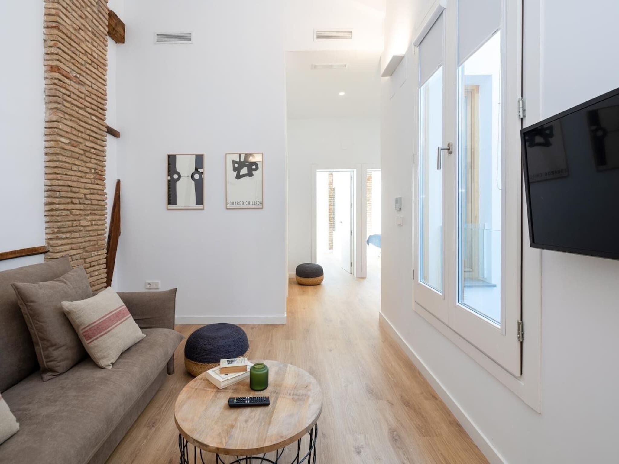 Ein modernes Wohnzimmer mit einer Couch, einem Couchtisch und Kunstwerken an der Wand.