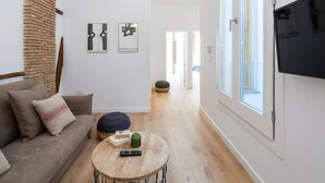 Una sala moderna con sofá, mesa de centro y una obra de arte en la pared.