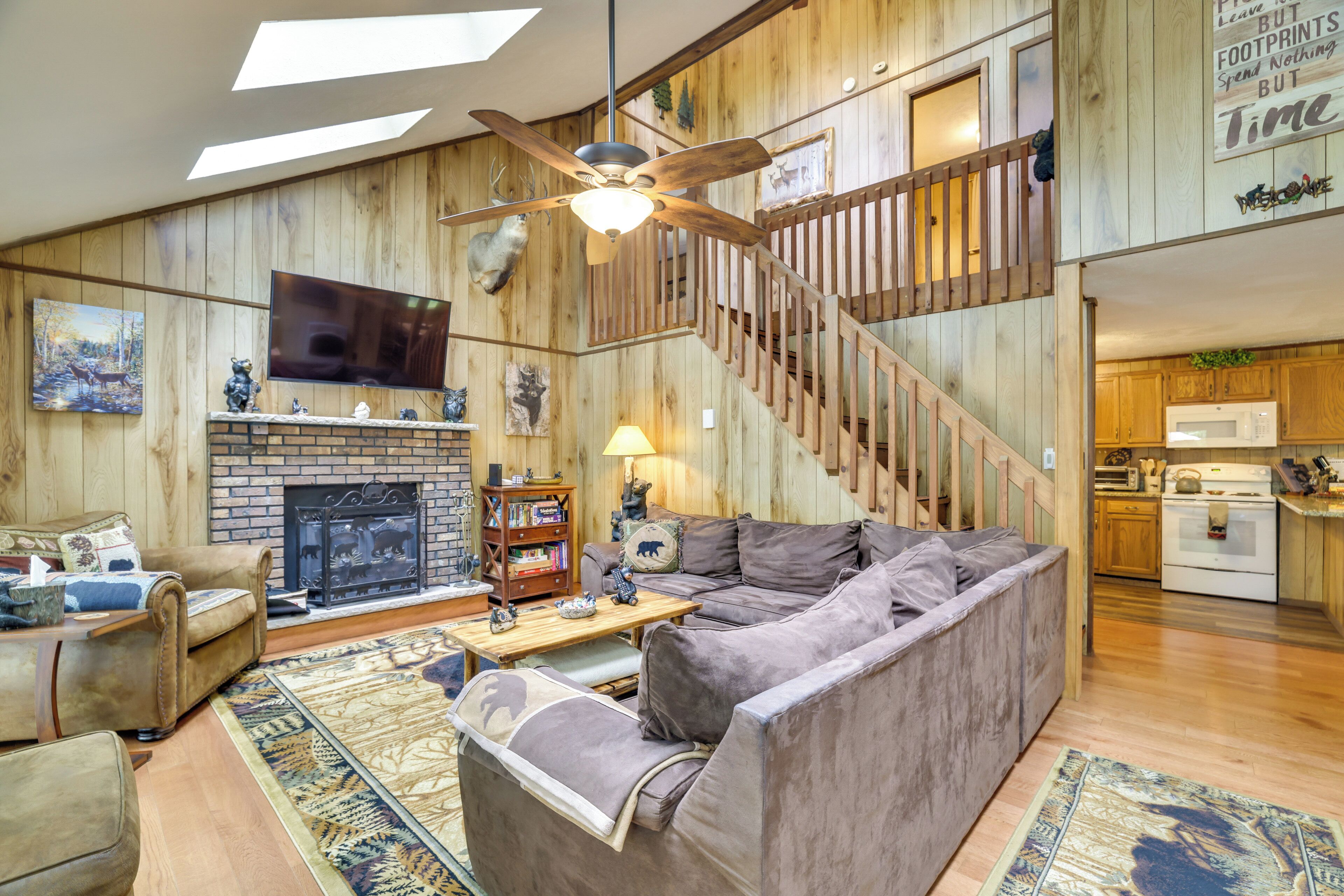A living room with a fireplace, a sofa, a television, and a staircase.