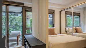 A modern bedroom with a large sliding glass door leading to a balcony, a sofa, and two beds with pillows. - Vossa Bossa Vila Madalena Diseño (São Paulo)