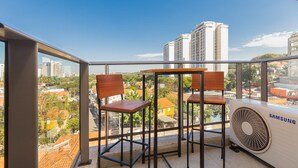 A balcony with two wooden chairs and a Samsung air conditioner. - Vossa Bossa Vila Madalena Diseño (São Paulo)